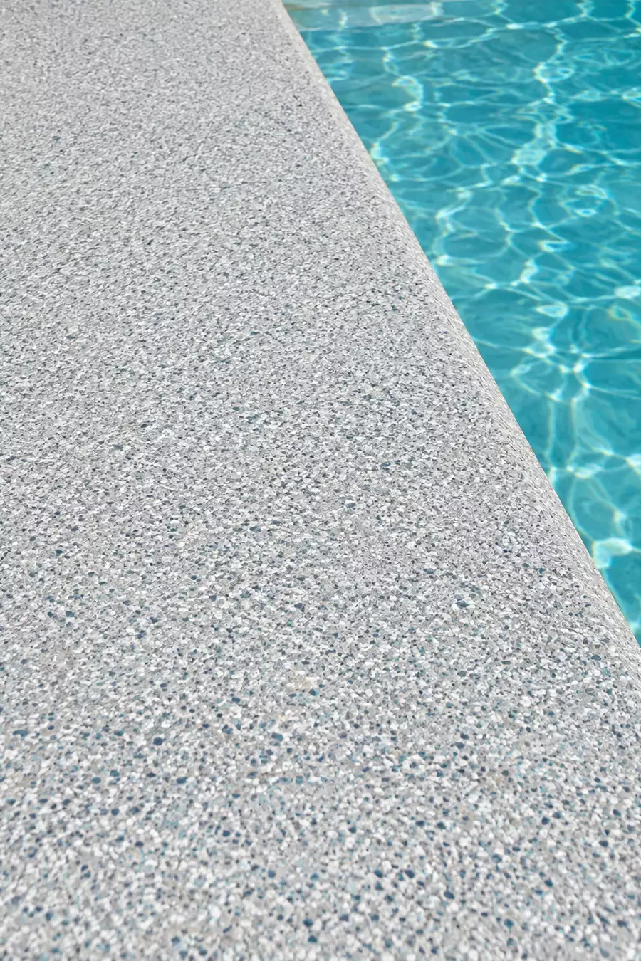 Gray flake pool deck coating close-up beside the water in Tampa, FL